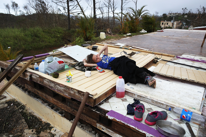 Karlian Mercado, 7, rests on the rubble that remains of her family’s home after it was blown away by Hurricane Maria as it passed through the area, on Sept. 24, 2017, in Hayales de Coamo, Puerto Rico. (Joe Raedle/Getty Images)